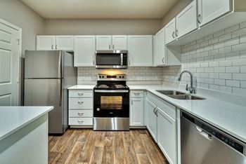 a kitchen with white cabinets and stainless steel appliances